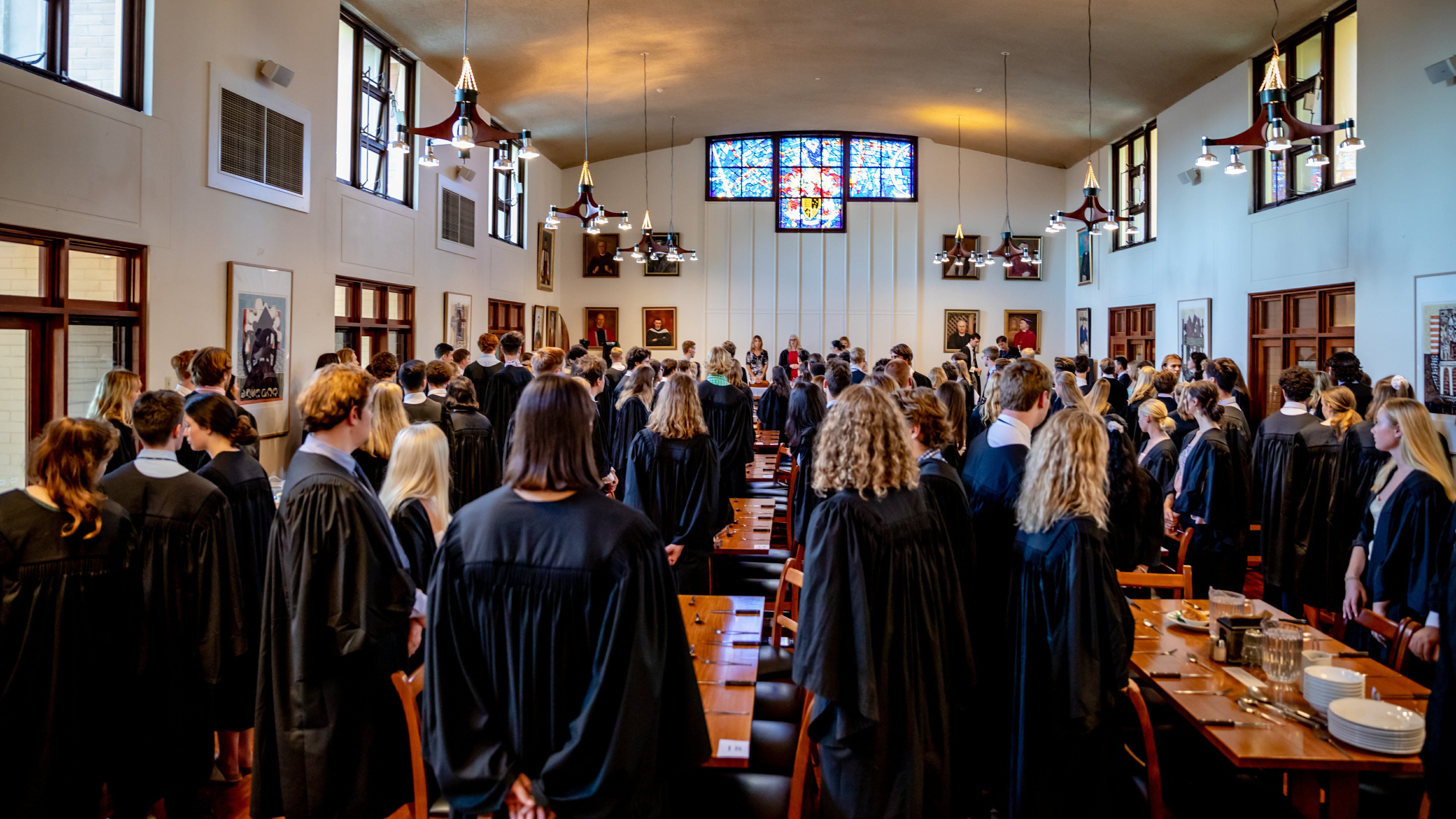 Students in formal robes at UQ residential college dinner