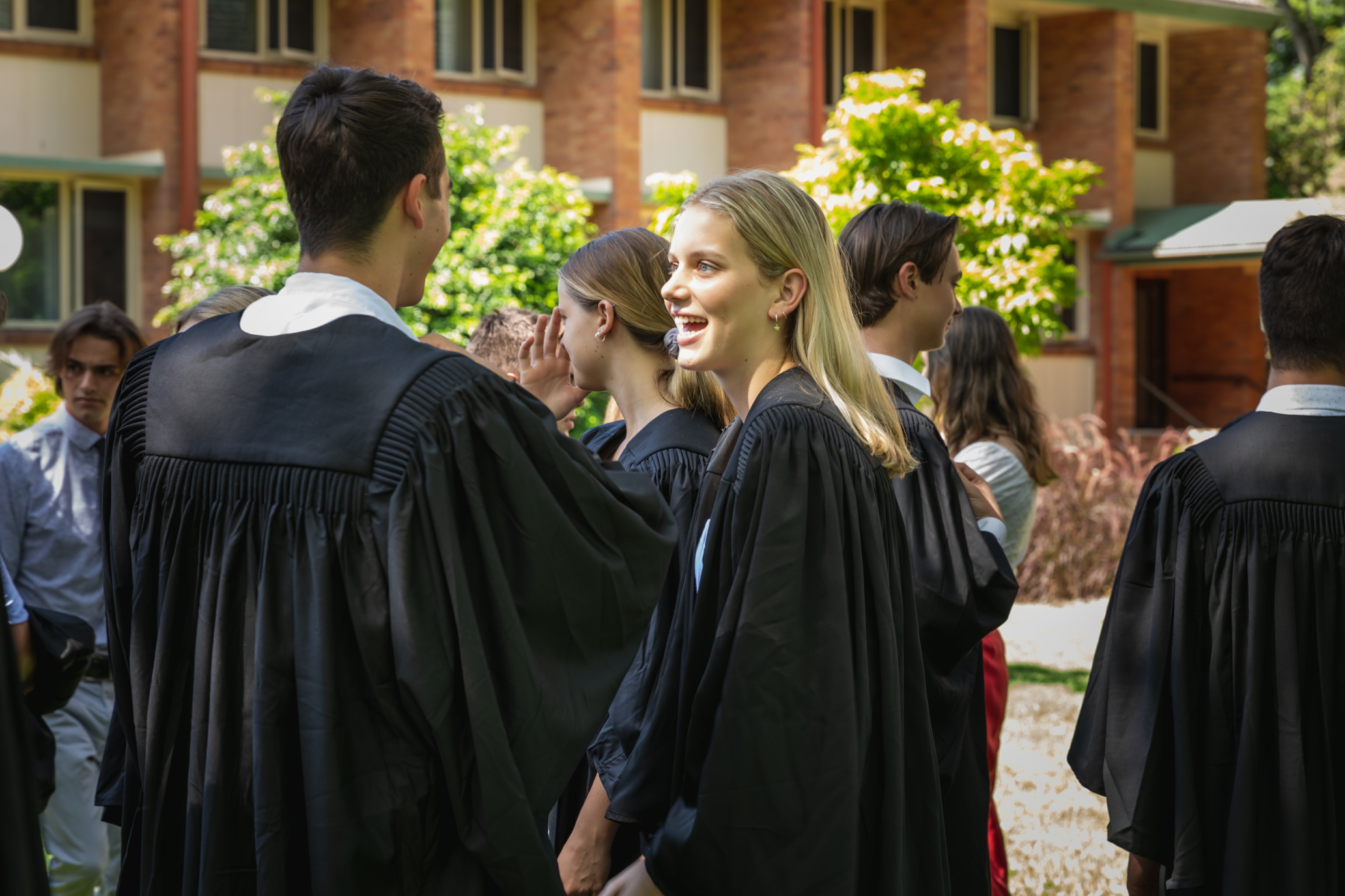 Students gathering in robes in the SJC grounds